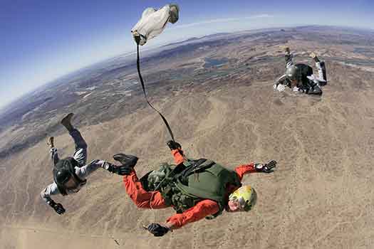 due istruttori e un allievo in volo durante lezione pratica di paracadutismo